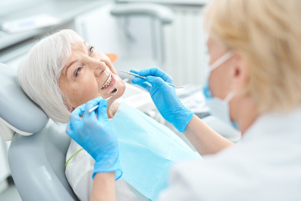 Doctor checking the teeth of a senior woman.