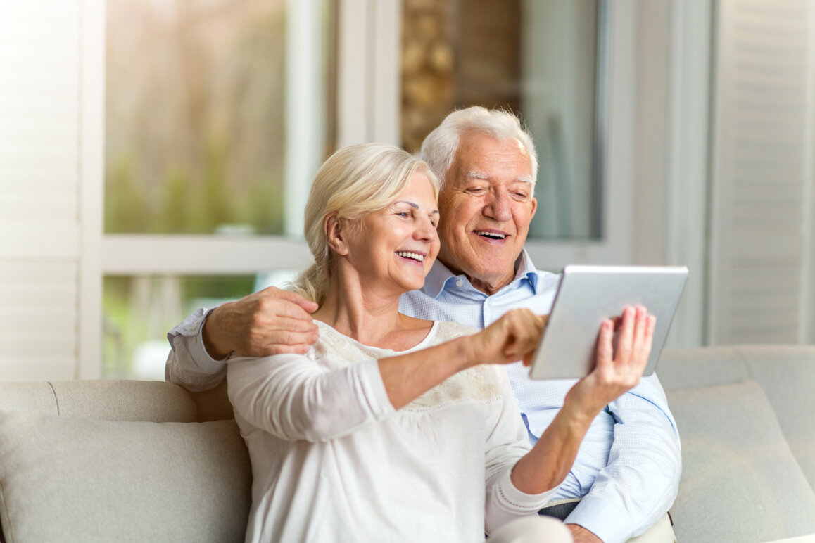 Senior couple using digital tablet at home.